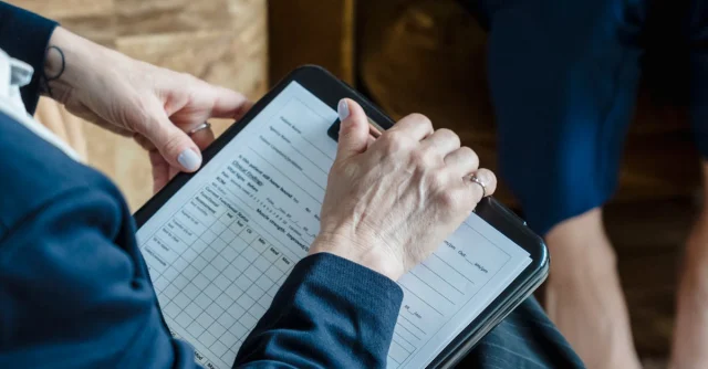 Hands holding a clipboard in a professional setting during a counseling session.